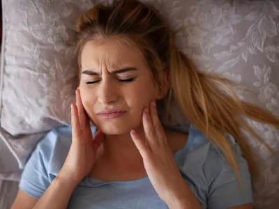 Woman with jaw pain from nighttime teeth grinding